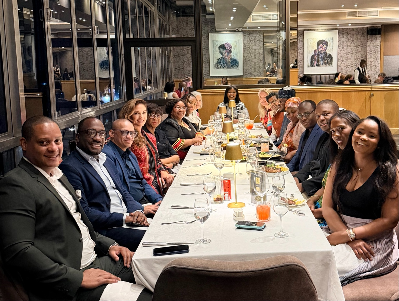 Adrienne Westman at a long dinner table with international and African delegates